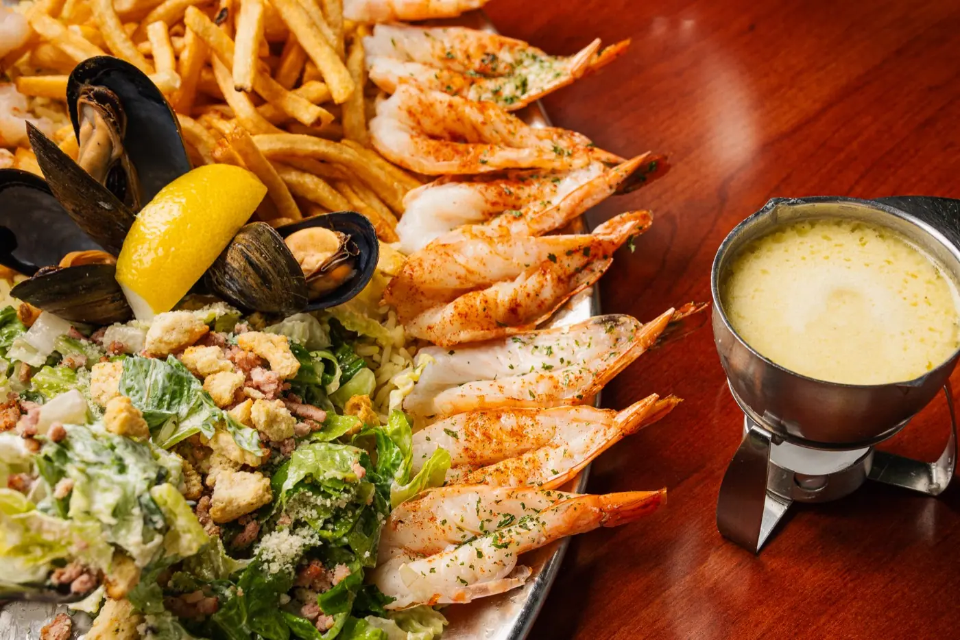 Table de fruits de mer chez Crevettes Plus : crevettes, frites et sauce au beurre